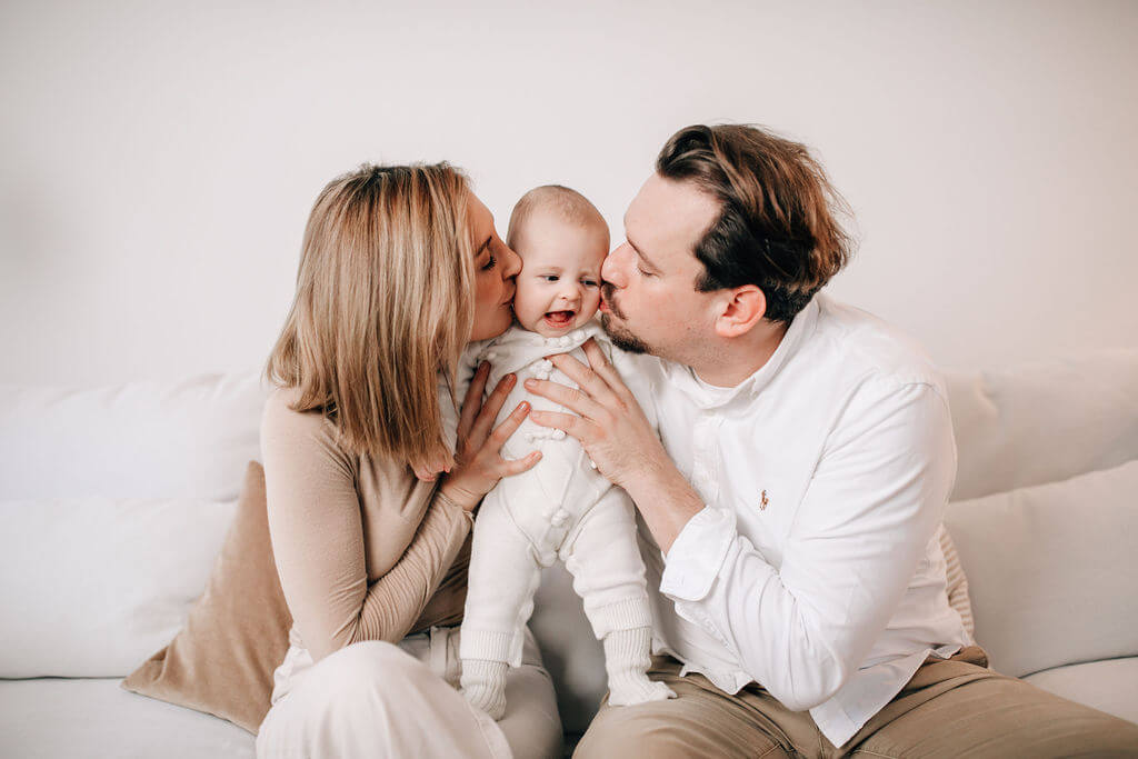 Eltern küssen ihr Baby